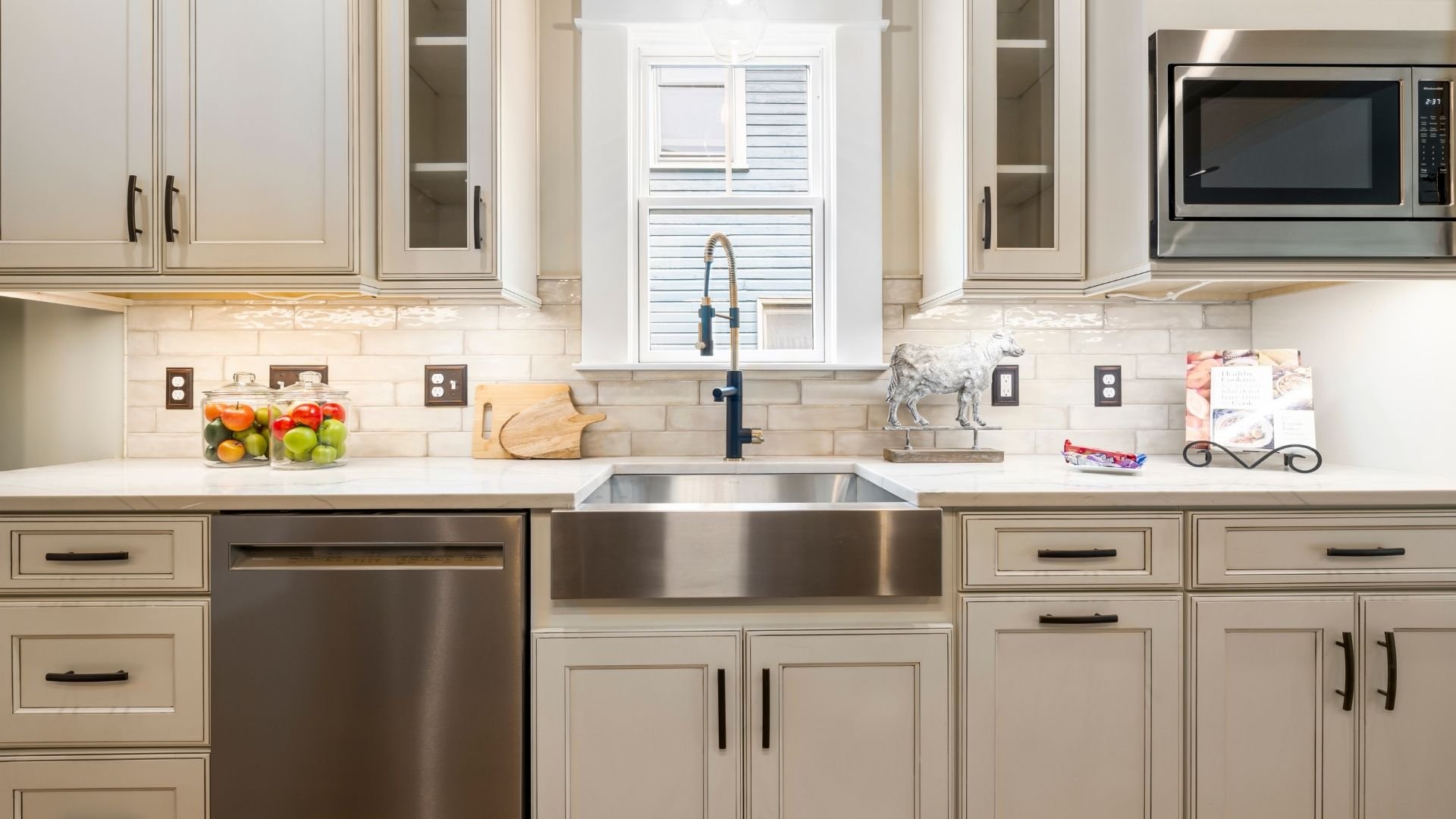 Modern kitchen with cream cabinets, stainless steel sink, and subway tile backsplash